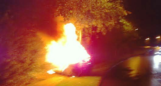 The crashed car on fire at "The Bywash" on Creggan Road in Derry last night.