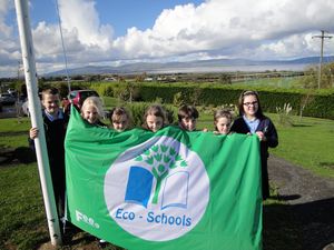 Pupils raising the Green Flag at Faughanvale Primary School.