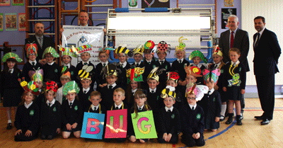 St Patrick's P1 Primary School pupils who were the first to to sign the "Pupils' Pledge Peace" scroll as part of a Guinness World Record attempt initiated by Rev David Latimer. Included, from left, are  Michael McCafferty production manager, Hunter Apparel Solutions, principal Eamon Devlin, WELB Senior Education Officer Paddy Mackey and Simon Hunter. managing director, Hunter Apparel Solutions who supplied the Fabric Scroll Signature machine.