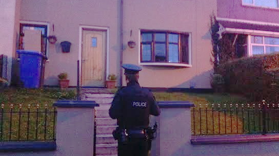 A police offer outside the Bradley home in Creggan,