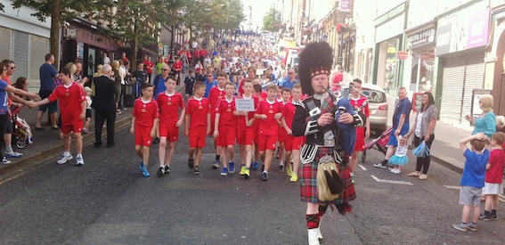 Lone piper William Robb leading the second half of the parade down Shipquay Street into Guildhall Square.