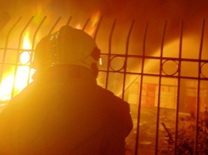 Firefighters cooling down shops next to the bonfire.