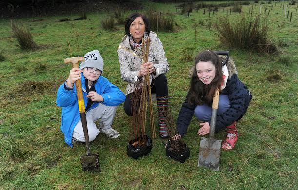 Calum Spain and Amy, Ebrington Primary School pupils, getting a helping hand fromb Mayor of Derry, Cllr Brenda Stevenson, to plant trees at Brackfield Wood. Photo: Declan Roughan