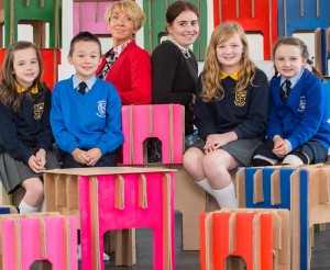 Pupils Lucy Montgomery (Ebrington PS), Liam Condren (Nazareth House PS), Erin Haire (Ebrington PS) and Amy Hutcheon (Nazareth House PS) with Maureen McLaughlin from Diamond Corrugated and Charlotte Tracey learning assistant Turner Prize 2013, testing out cardboard furniture that Diamond Corrugated has created for the Learning Programme of Turner Prize 2013 in Derry as part of the partnership.