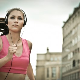 Young person listening misic running in city street