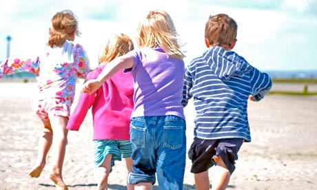 Children playing on British coastal beach in the summer