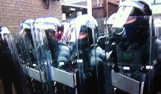 Police in riot gear at the front gate of Antrim police station during the stand-off with loyalist protestors.