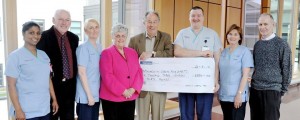 Nelson McCausland presenting a cheque for £6,330 to Coronary Care Unit at Altnagelvin. Included Staff Nurse Shiny Joseph, Cardiac Rehab Nurse Shirley McGaffin, Norman Boyd, Margaret McGonagle, Nursing Auxillary Jimmy Harkin, Cardiac Rehab Nurse Celia Rafferty and Peter Cassidy.