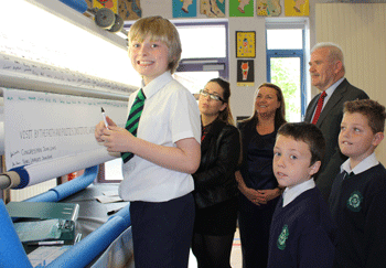 Lining up to sign their signature on the "Pupils Peace Pledge" scroll are US Congressman John Lewis and Nobel Laureate John Hume along with pupils from St Patrick's PS, Pennyburn. Also included are Shauna Crossan, A Level pupil at St Cecilia's College, vice-principal Mrs McConnell-Logue and WELB Senior Education Officer Paddy Mackey.