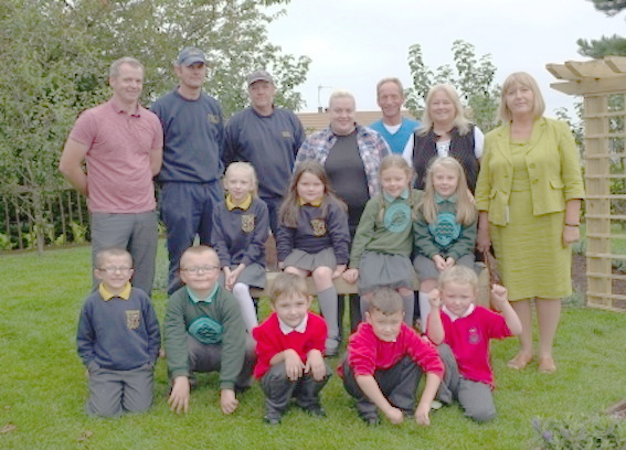 Children from local schools helping Housing Executive staff and community representatives with the makeover of the Caw Orchard.