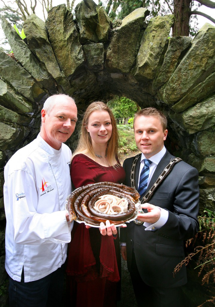Derry chef Emmett McCourt is pictured offering a tempting taste of smoked Lough Neagh Eel to medieval maiden Ingrid Houwers and Councillor Thomas Hogg, Mayor of Antrim and Newtownabbey Borough Council.