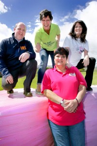Beverley Caldwell (left) and Eileen Curran (right), from The Pink Ladies Cancer Support Group, are pictured with Danny McErlaine and Celine McLarnon from ISL Waste Management, and the pink wrapped bales that will mark milestones on a fundraising journey to raise a target donation of £10,000.