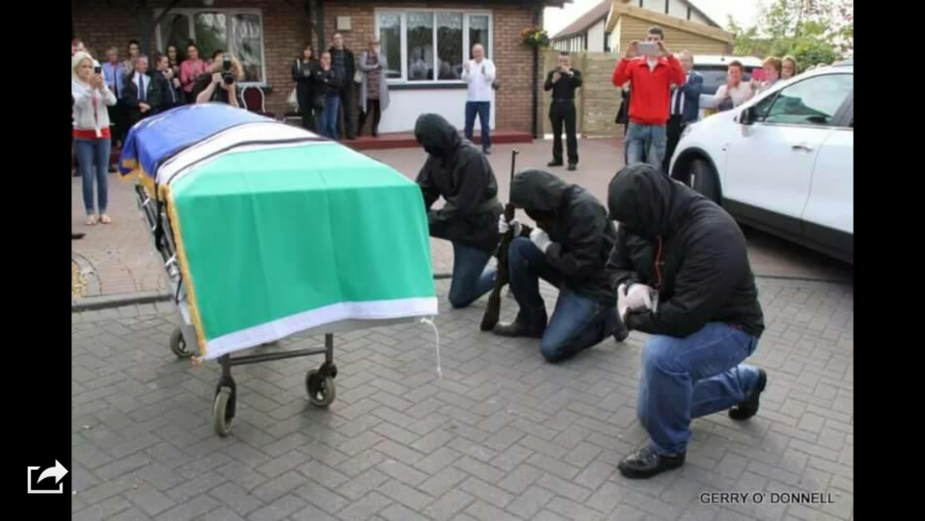 Masked and armed men kneel at the Tricolour draped coffin of Peggy O'Hara