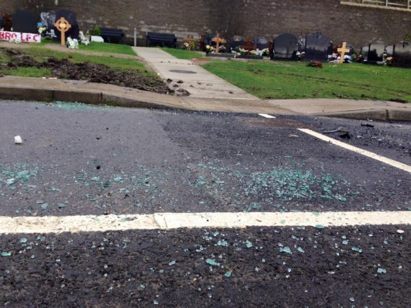 Debris lies on the road following a controlled explosion on a car found to have two guns onboard